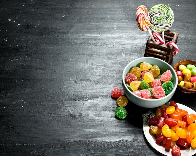 Different baby sweets in bowls. On the black chalkboard.