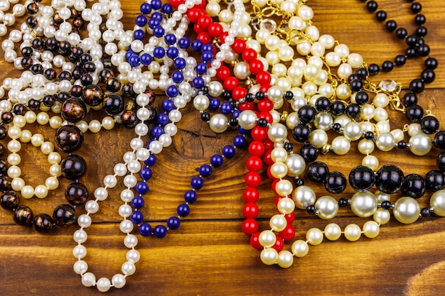 Different beads necklaces on wooden background