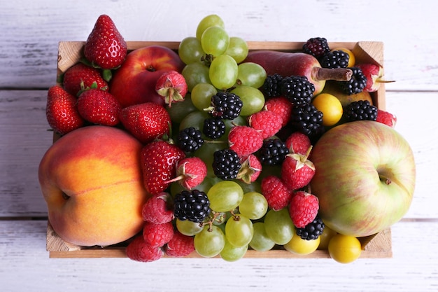 Different berries and fruits on wooden table closeup