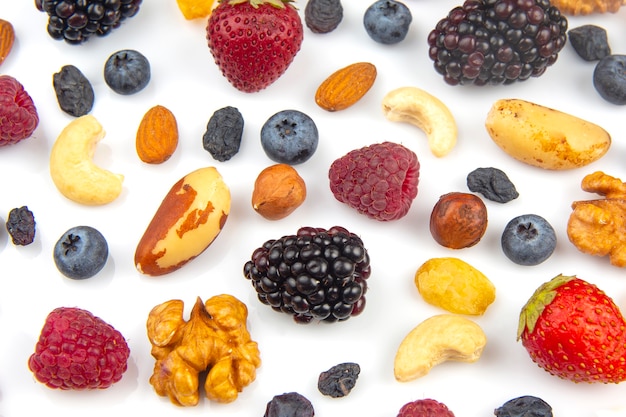 Different berries and nuts on a white