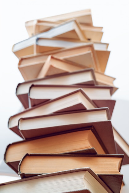 Different books on top of each other. Stack of books in library. Scientific, educational, and fiction paper books. Education and training.