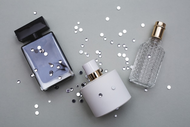 Different bottle of perfume in grey background