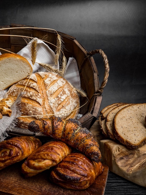 Different bread buns in basket on concrete background copy space