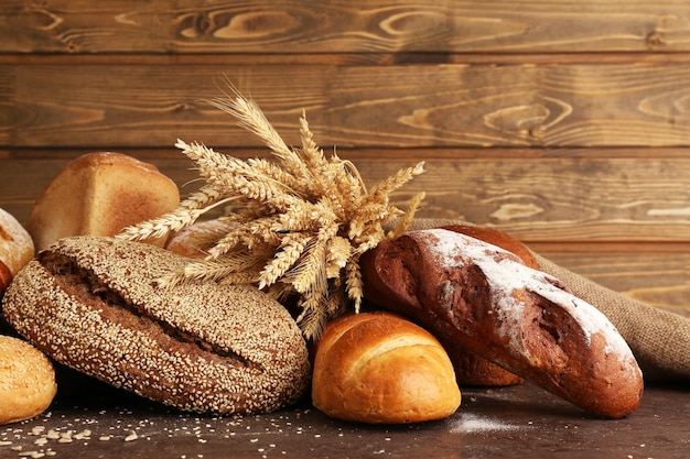 Different bread with ears on wooden background