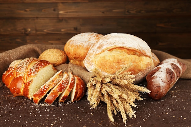 Different bread with ears on wooden background