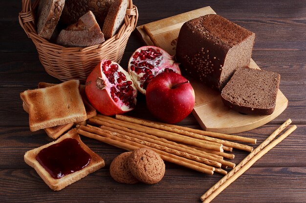 Different buns of fresh bread and spikelets of wheat on a brown vintage background