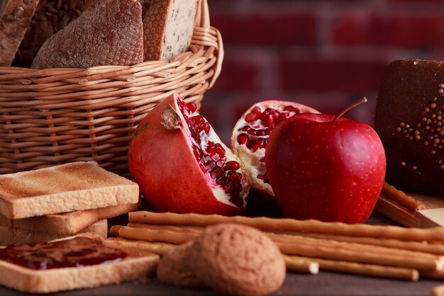 Different buns of fresh bread and spikelets of wheat on a brown vintage background