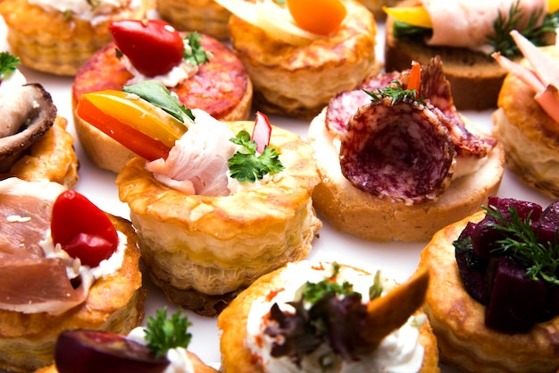 Different canapes with smoked salmon, cucumber cherry tomatoes and mozzarella served on a table