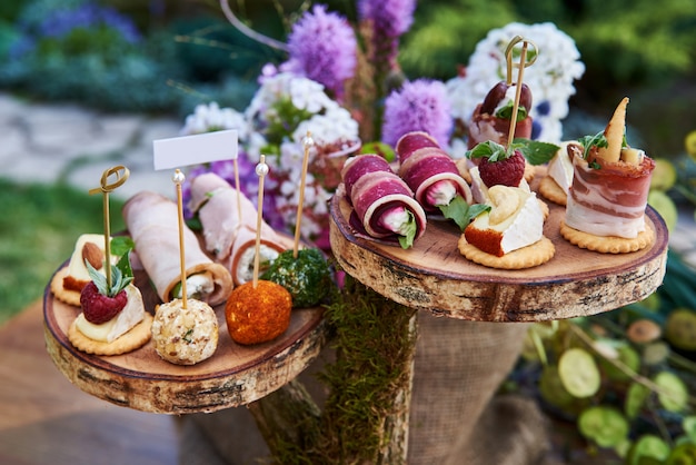 Photo different canapes with smoked salmon, cucumber, tomatoes, cheese, meat. breakfast buffet table with a variety of snacks. buffet served table with snacks,fruits,canape,sweets and appetizers.