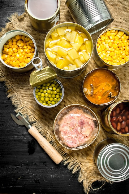 Different canned products in tin cans. On the black chalkboard.