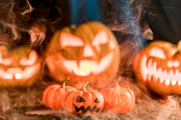 Photo different carved pumpkins with smoke