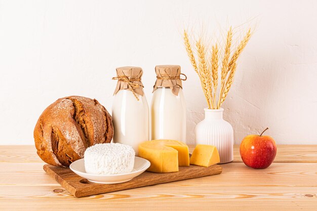 A different cheese bread cottage cheese sour cream milk in bottles on a wooden countertop Concept of the Jewish holiday of Shavuot Front view