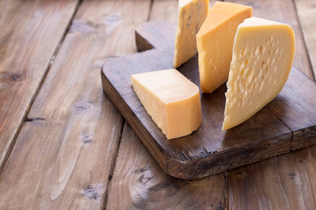 古い木の板にさまざまなチーズ。ダッチチーズ