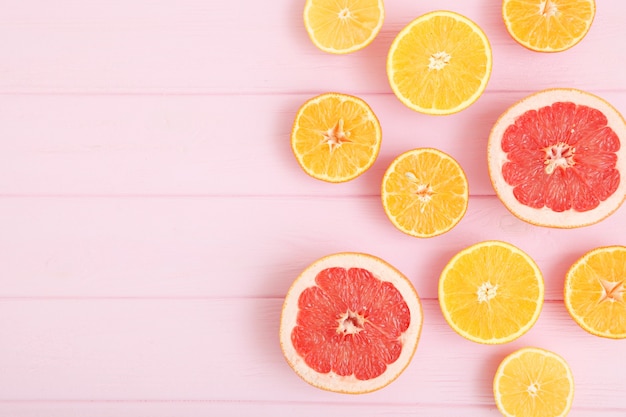 Different citrus and juicy slices on a colored background place to insert text