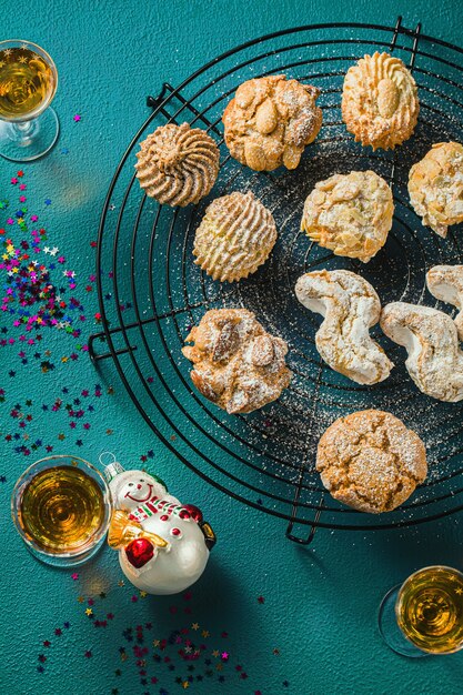 Different classic Italian homemade almond cookies with espresso coffee and glasses of sweet liquor on the table, Christmas decor