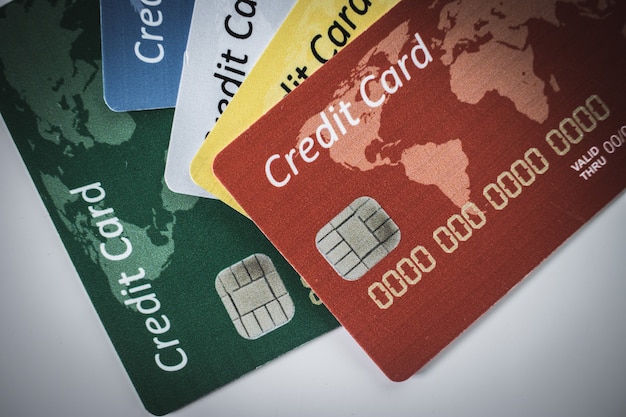Кредитная карта разного цвета с чипами, лежащая на белом заднем