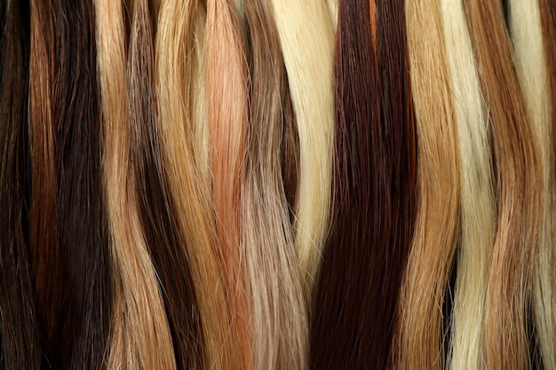 Different color female hair on whole background, close up