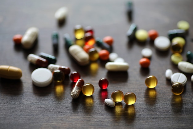 Different colored medications and tablets on a wooden texture table