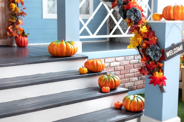 Different colored pumpkins in front door On Wooden Steps