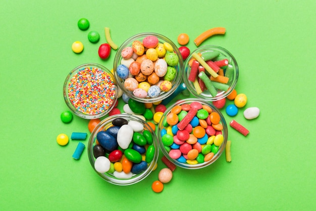 Разноцветные круглые конфеты в миске и банках Вид сверху на большое разнообразие сладостей и конфет с копией пространства