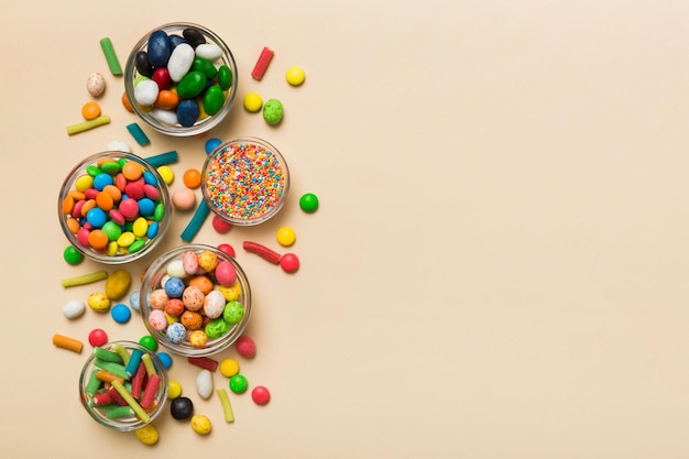 different colored round candy in bowl and jars Top view of large variety sweets and candies with copy space