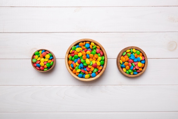 different colored round candy in bowl and jars Top view of large variety sweets and candies with copy space