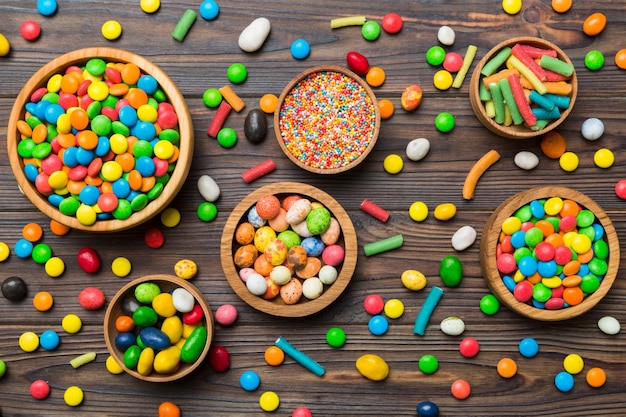 different colored round candy in bowl and jars Top view of large variety sweets and candies with copy space