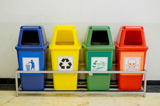 Photo different colored wheelie bins set with waste icon