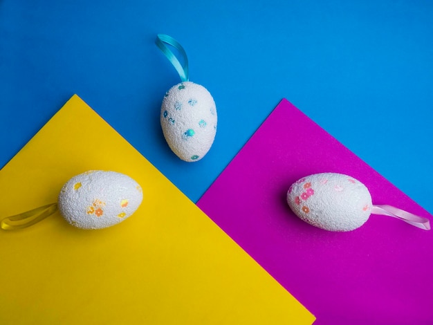 Different colorful eggs on bright background in trendy colors Easter concept