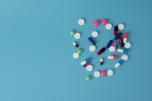 Different colorful medicine pills on table