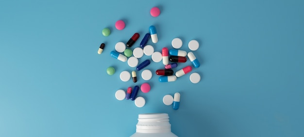 Different colorful medicine pills on table