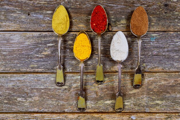 Different colorful spices in spoons. Healthy with herbs and spices