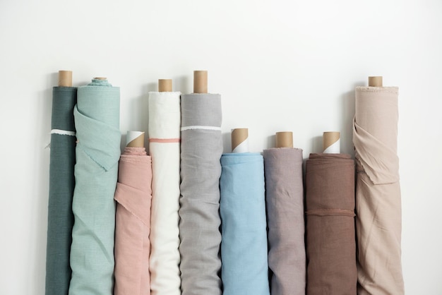 Different colors fabric linen rolls on the white walls selective focus image