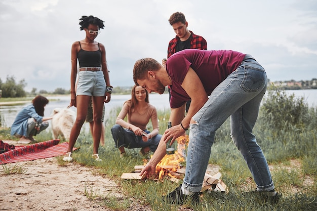 Разные культуры, одно место. Группа людей устраивает пикник на пляже. Друзья веселятся в выходные.
