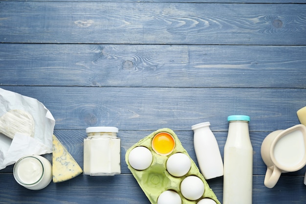 Photo different dairy products on color wooden table background