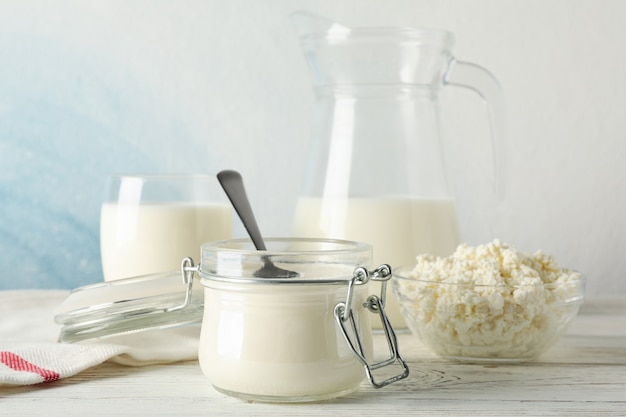 Different dairy products on white wooden background