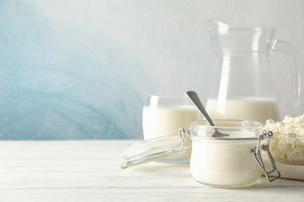 Different dairy products on white wooden background