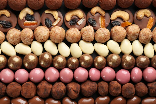 Different delicious chocolate candies as background closeup