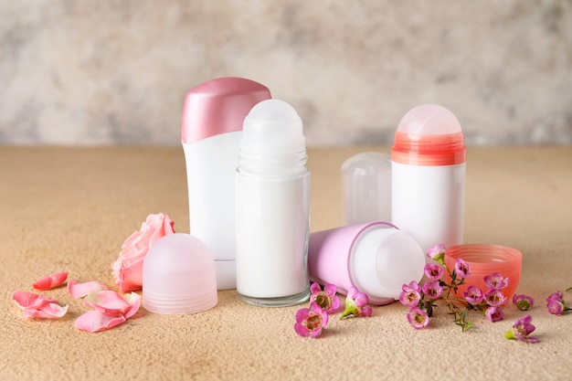 Different deodorants and flowers on table