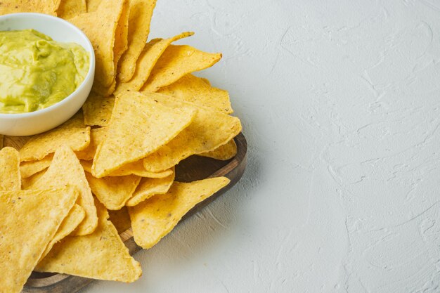 Different dips and sauces for nachos, on white table