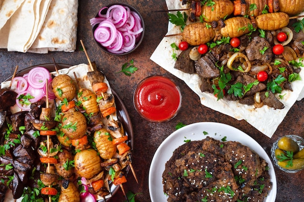 Different dishes of liver kebab skewered liver whole vegetables\
and mushrooms on skewers