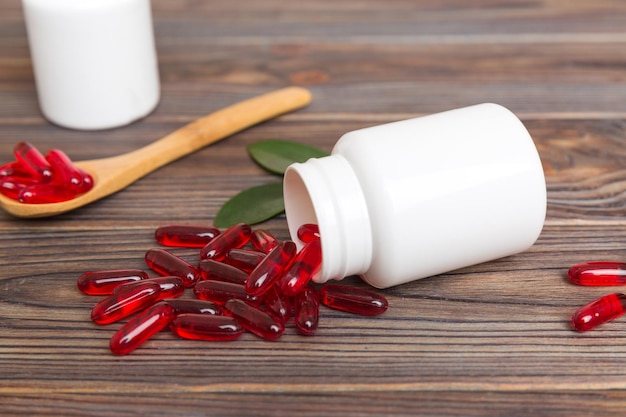 Different drugs and health supplement pills poured from a medicine bottle health care and medical top view on colored background