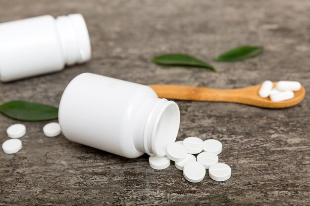 Different drugs and health supplement pills poured from a medicine bottle health care and medical top view on colored background