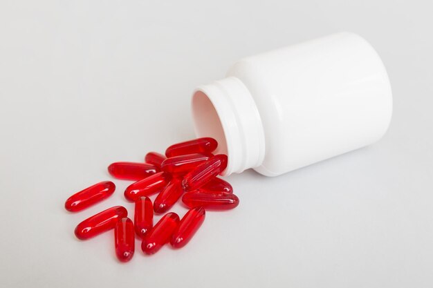 Different drugs and health supplement pills poured from a medicine bottle health care and medical top view on colored background