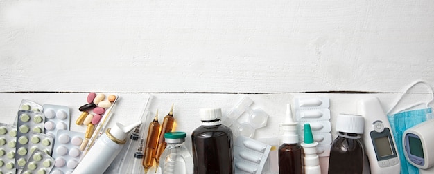 different drugs, pills and other medicine on wooden white table