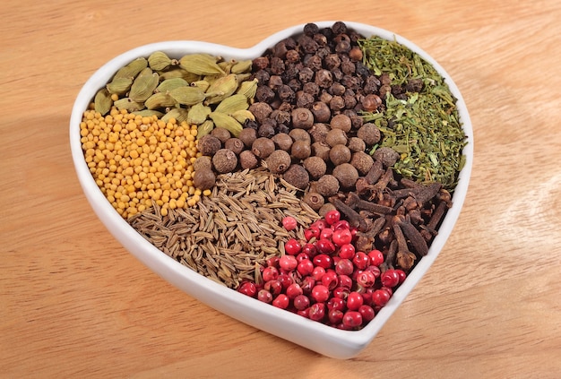 Different dry spices in plate in the form of heart