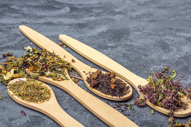 different dry teas in wooden spoons line