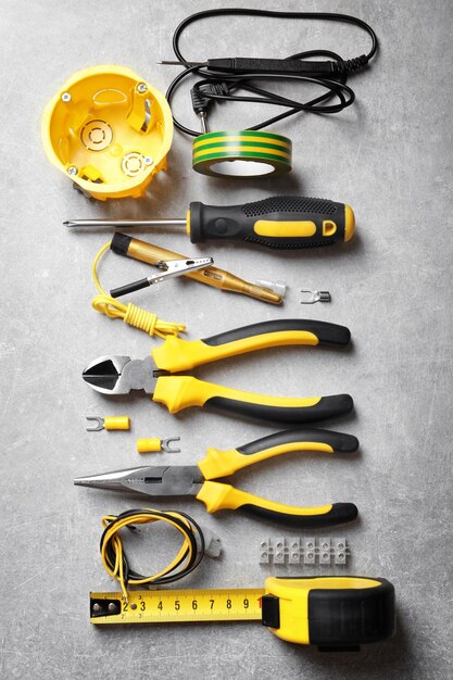 Different electrical tools on grey background