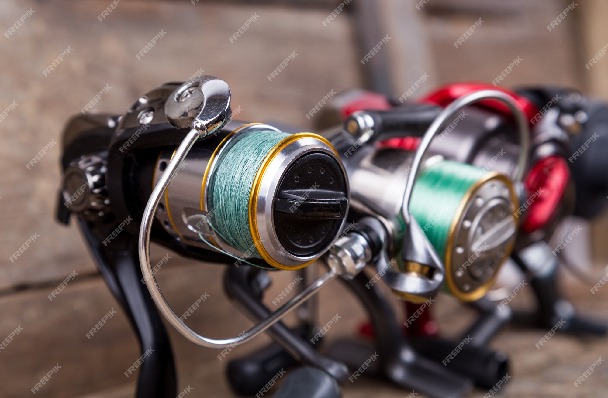 Premium Photo  Different fishing reels with line on wooden table
