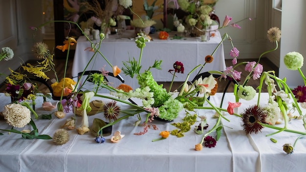 Different flowers scattered on white table